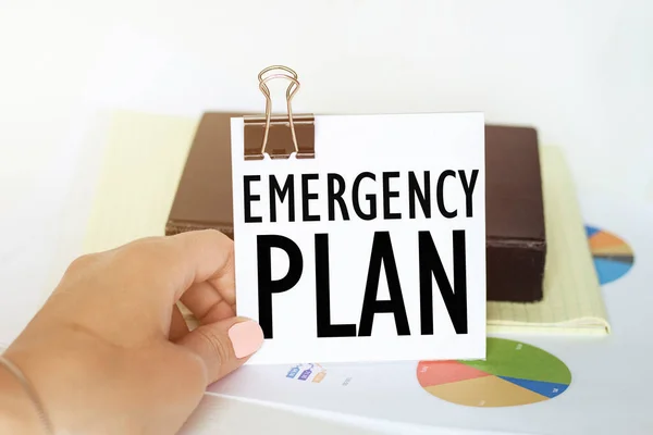 Womans Hand Holds Piece Paper Text Emergency Plan Background Graphs — Stock Photo, Image