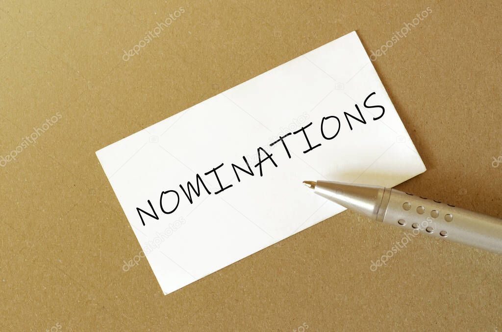 pen, white paper with text Nominations on the brown background