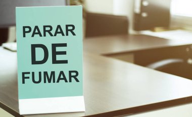 Ofis arka planında PARAR de FUMAR yazılı mavi tahta