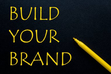 Siyah arka planda sarı yazılı sarı kalemli markanızı oluşturun.