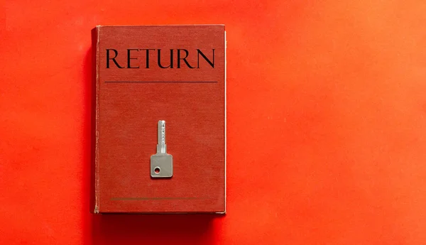 Kırmızı Arkaplanda Kırmızı Bir Anahtar Metin Return Ile Kırmızı Kitap — Stok fotoğraf