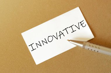 Kalem, beyaz kağıt ve kahverengi arkaplan üzerinde Innovatory