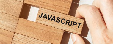 Erkek eli diğer tahta parçalarından JAVASCRIPT yazısıyla bir tahta parçasını itiyor