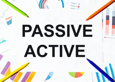 Grafiklerin arka planında PASSIVE ACTIVE yazılı beyaz kağıt parçası, çok renkli keçeli kalemler