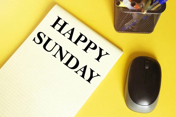 computer mouse, pens, felt-tip pens, notepad with text HAPPY SUNDAY on a yellow background