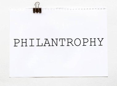 Kırtasiyeli beyaz arkaplan üzerinde PHILANTROPHY metin içeren beyaz kağıt