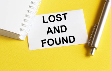 Yazılı beyaz kağıt kayıp ve kırtasiyeli sarı bir arkaplanda bulundu