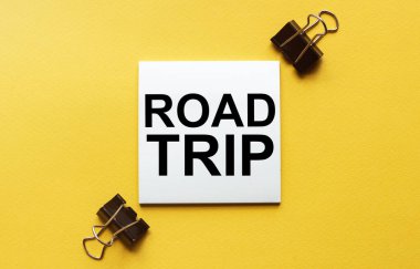 Kırtasiyeli sarı arkaplan üzerinde metin yolu gezisi olan beyaz kağıt