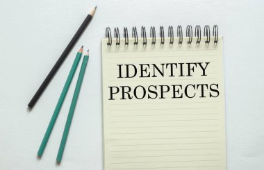 Beyaz arkaplandaki defterde iki yeşil bir siyah kalem ile metni tanımla