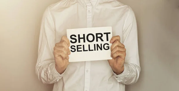Man Neem Een Papier Met Tekst Short Selling Het Shirt — Stockfoto