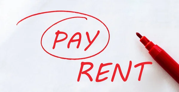 white paper with text Pay Rent on the white with red marker