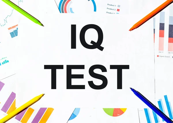 white piece of paper with text Iq Test on the background of the graphs, multi-colored felt-tip pens