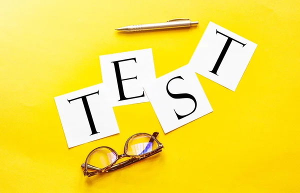 Sarı Arkaplan Kalem Gözlüklü Metin Testi Içeren Beyaz Kağıt — Stok fotoğraf