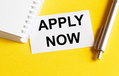 Metin ile beyaz kağıt Şimdi kırtasiye ile sarı arkaplan üzerinde Uygula