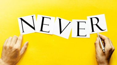 Yazılı beyaz kağıt Asla insan eli ile sarı bir arkaplanda değil