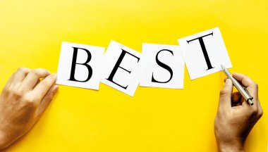 Yazılı beyaz kağıt En iyi insan eli ile sarı arka planda