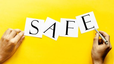 Sarı arka planda insan eli ile güvenli beyaz kağıt