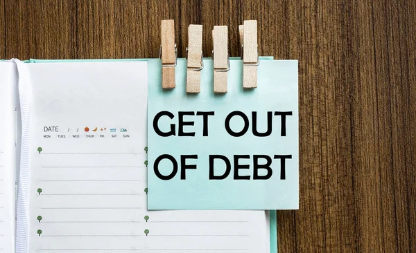 Get Out Debt Notes Papier Und Eine Wäscheklammer Auf Holzgrund — Stockfoto