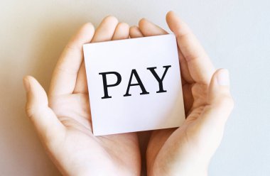 Yazılı beyaz kağıt. Beyaz arka planda erkek eli ile ödeme.