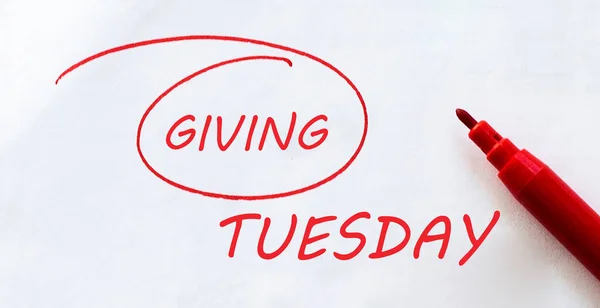 white paper with text Giving Tuesday on the white with red marker