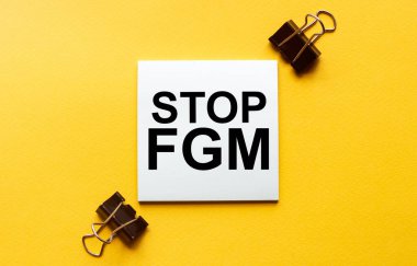 Yazılı beyaz kağıt Kırtasiyeli sarı arkaplan üzerindeki Fgm 'i durdur