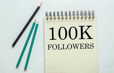 iki yeşil bir siyah kalem ile metin 100K beyaz arkaplanda defter takipçileri