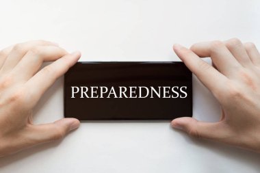 Erkek elleri siyah telefonu tutuyor. Beyaz arkaplanda metin hazırlığı var.