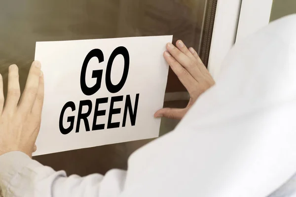 Man Hangs Notice Glass Door Text Green — Stock Photo, Image