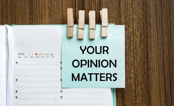 Your Opinion Matters notes paper and a clothes pegs on wooden background