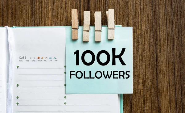 100K Followers Σημειώσεις Χαρτί Και Ένα Μανταλάκι Ρούχα Ξύλινο Φόντο — Φωτογραφία Αρχείου