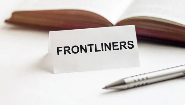 Лист Бумаги Текстом Frontliners Фоне Книг Ручек Белом Фоне — стоковое фото