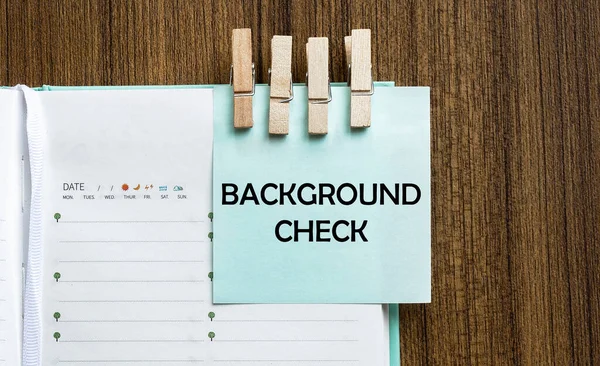 Geçmiş kontrolü notları kağıt ve tahta arka planda bir elbise askısı