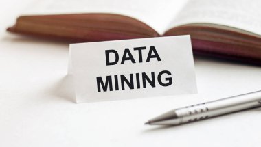 Beyaz bir arkaplan üzerinde kitap ve kalemlerin arkaplanını araştıran metin verisi içeren bir kağıt parçası