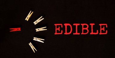 Siyah arkaplanda kırmızı ve kahverengi metin EDIBLE