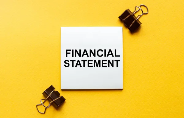 white paper with text Financial statement on a yellow background with stationery