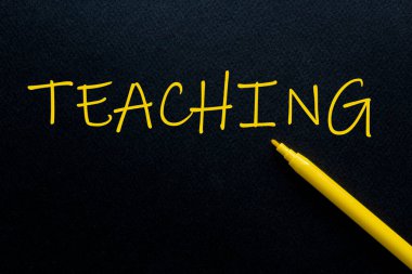 Siyah arkaplanda sarı yazılı sarı kalemli öğretmenlik.