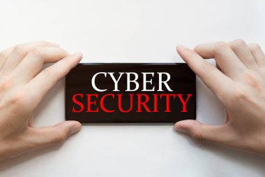 Beyaz arka planda siber güvenlik mesajı olan siyah bir telefon tutuyorlar.