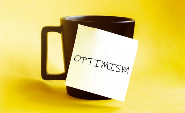 Weißes Papier Mit Text Optimismus Auf Der Schwarzen Tasse — Stockfoto