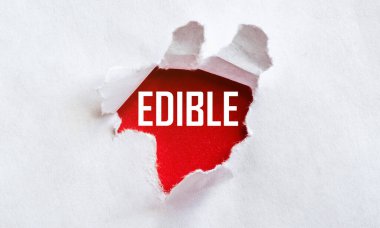 Kırmızı arkaplanda EDIBLE metni olan beyaz yırtık kağıt