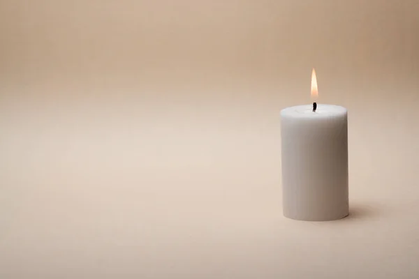 Zen like spa concept with only one candle on nice beige background.
