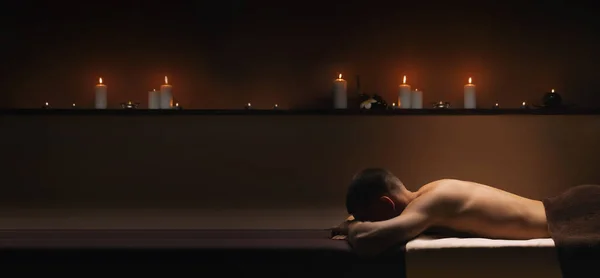 El hombre se relaja en el SPA. Ambiente tranquilo y pacificante alrededor . — Foto de Stock