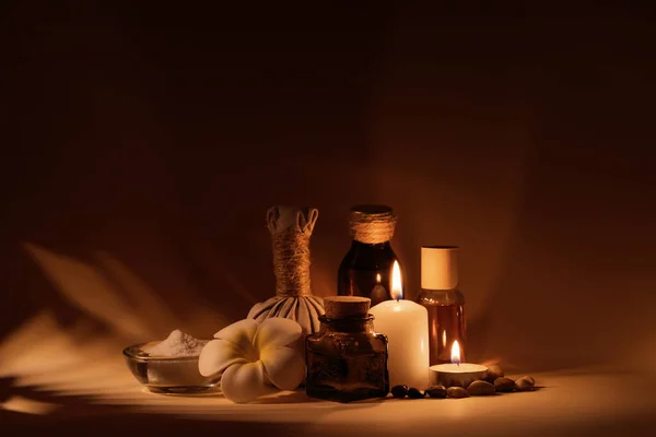 Mumlu güzel spa kompozisyonu, frangipani çiçeği, yağ şişeleri, tuzlu kase ve bitkisel top..