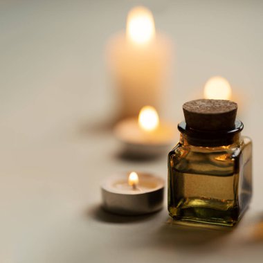Yağ şişesi ve mumlarla sade ve özlü spa kompozisyonu. Boşluğu kopyala