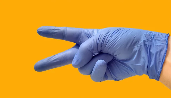 Закрытая Рука Открытым Большим Указательным Пальцами Голубой Перчатке Жёлтом Фоне — стоковое фото