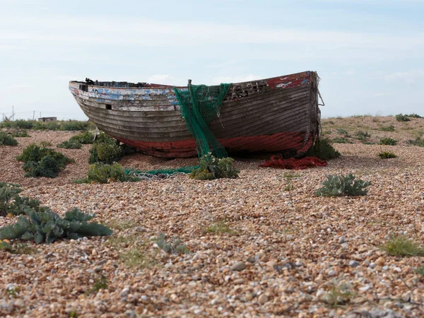 Dungeness sahilinde terk edilmiş bir balıkçı teknesinin gövdesi, İngiltere 'nin Kent sahilinde bir burnu, büyük ölçüde bir kiremit plajı şeklindeydi..