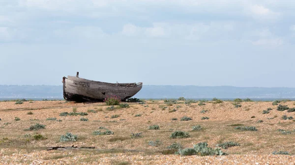 Dungeness sahilinde terk edilmiş bir balıkçı teknesinin gövdesi, İngiltere 'nin Kent sahilinde bir burnu, büyük ölçüde bir kiremit plajı şeklindeydi..
