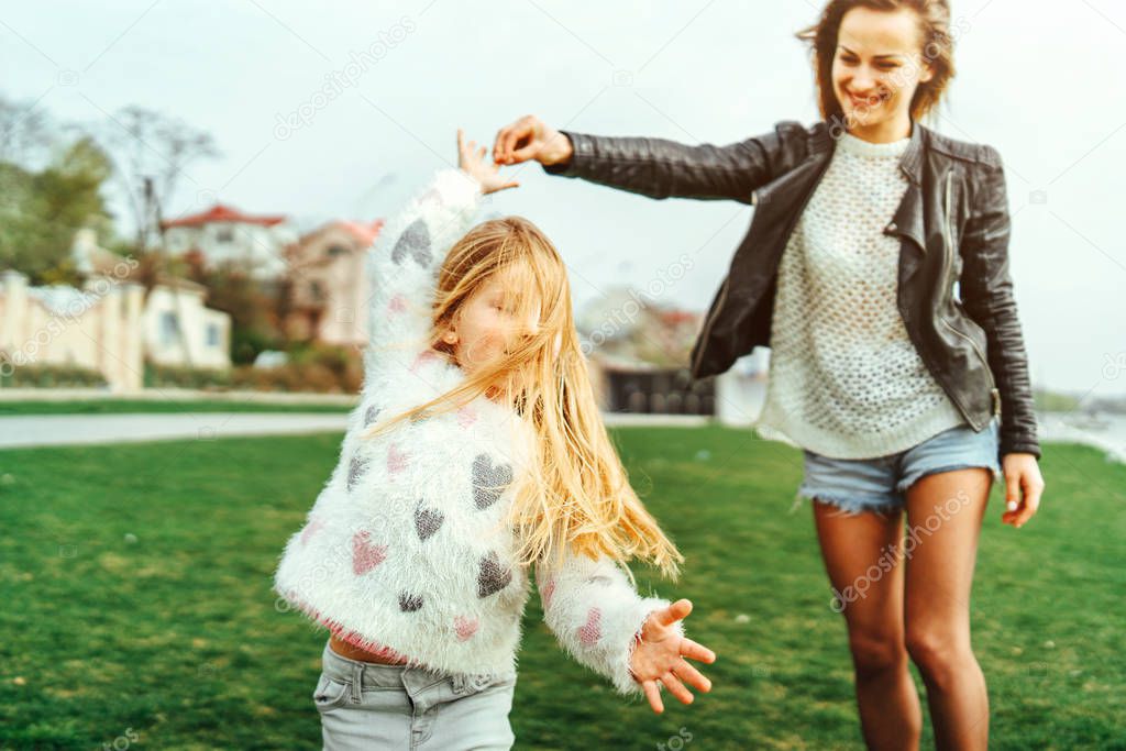 Mother with her little daughter have fun outdoors