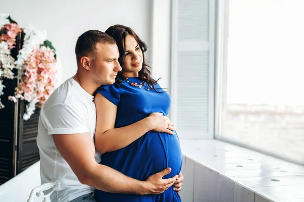 Portret Van Mooie Zwangere Vrouw Met Echtgenoot Knuffelen Binnenshuis — Stockfoto