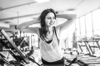Oldukça sportif kadının spor salonunda bankta karın egzersizleri yapması 