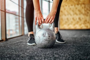 Sportif kadın Kettlebell spor salonunda yerden kaldırma